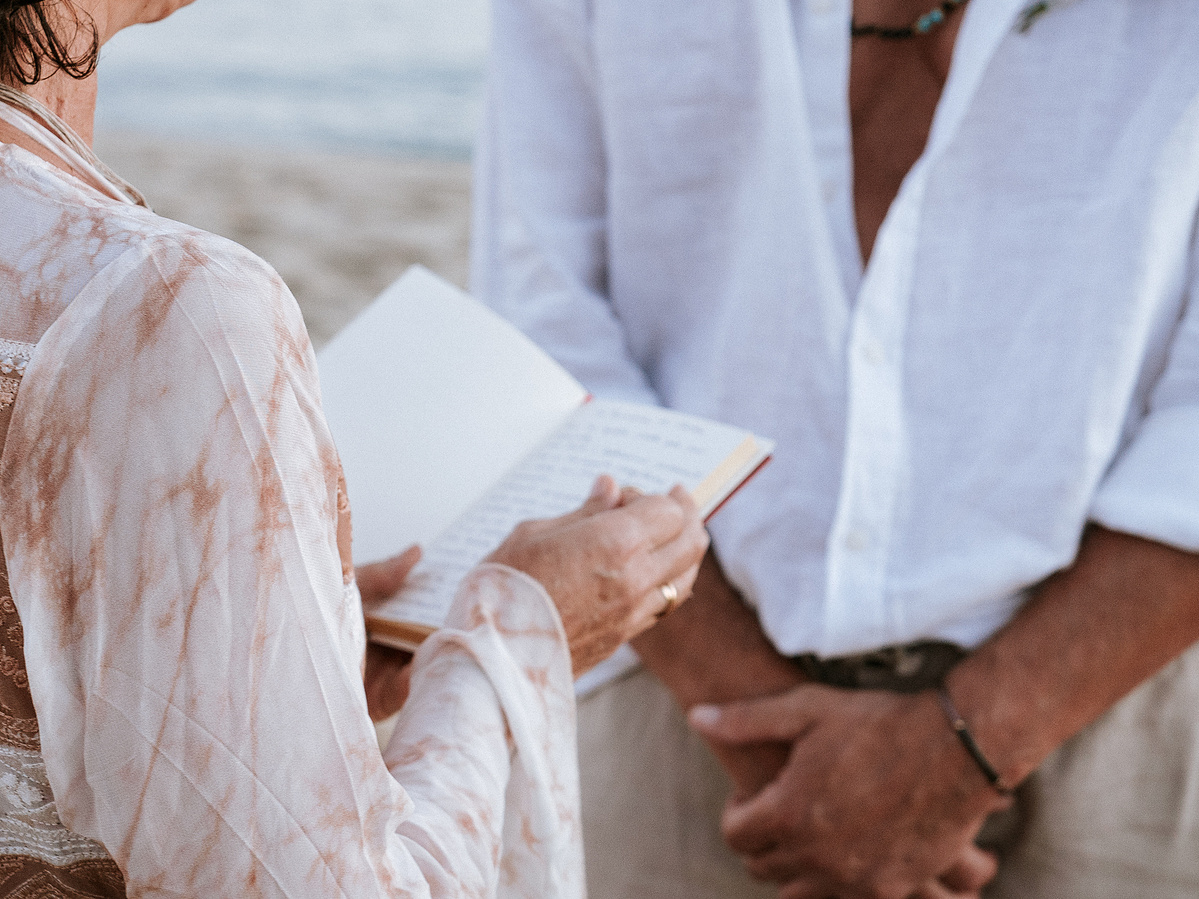 Couple reading their vows during a wedding ceremony by the sea